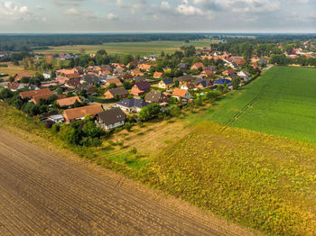 High angle view of houses by agricultural field against sky