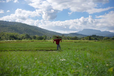 Scarecrow on field against sky