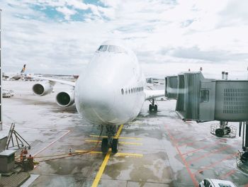 Airplane on airport runway against sky