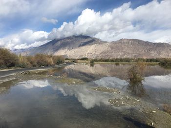 Scenic view of lake by mountains against sky