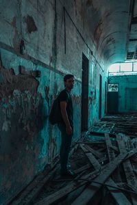 Full length portrait of man standing in abandoned building