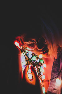 Close-up portrait of woman with light painting at night