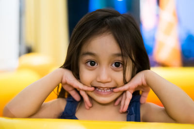 Close up of little asian girl, looking in camera with cute expression.