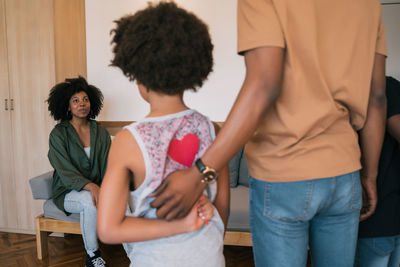 Woman looking at father with sons at home