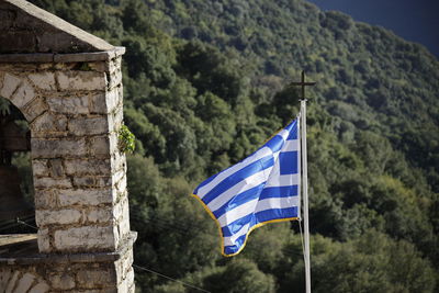 Low angle view of greek flag against mountain