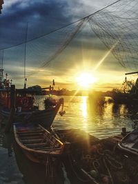 Boats moored on sea against sky during sunset