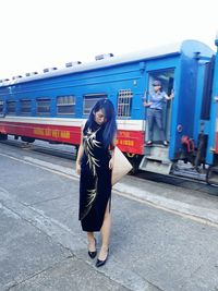 Full length of woman standing on train at railroad station