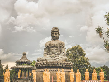 Statue against temple building against sky