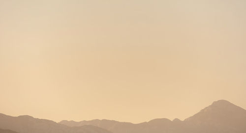 Scenic view of silhouette mountains against sky during sunset