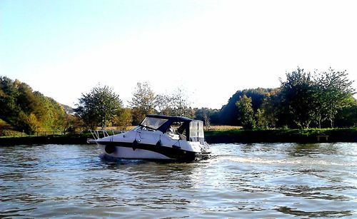 Boat in river against clear sky