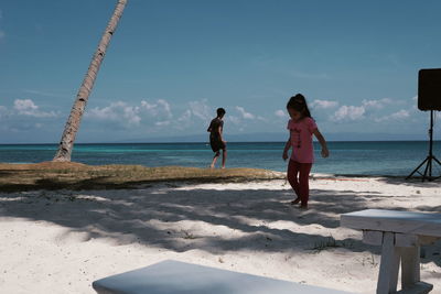 Women on beach against sky