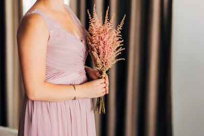 Midsection of woman holding flower