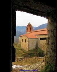 Buildings against sky seen through window