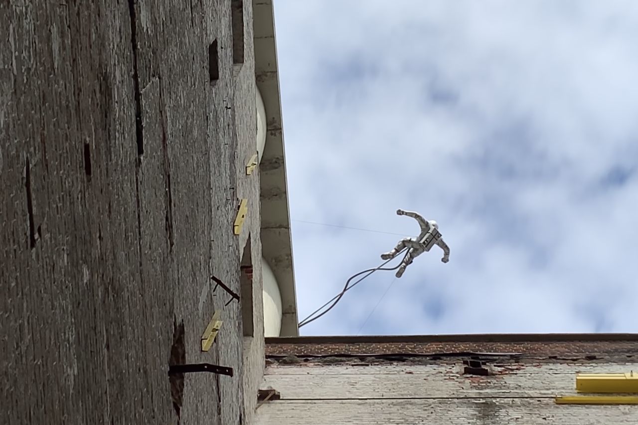 LOW ANGLE VIEW OF BIRD FLYING OVER WOODEN POST AGAINST SKY