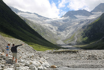 Father and son standing on rocks against mountains at australian alps