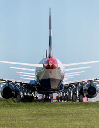 Airplane on airport runway against sky