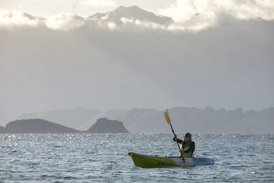 One woman paddling on a seat on top kayak close to the shore of carmen island in loreto, baja california, mexico.