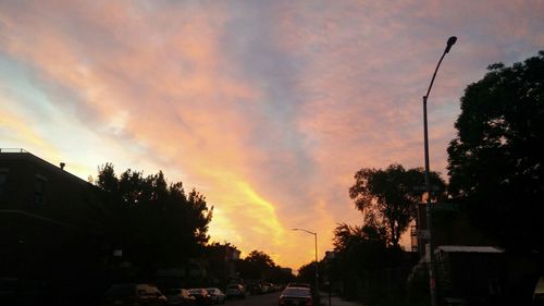 Cars on road against cloudy sky