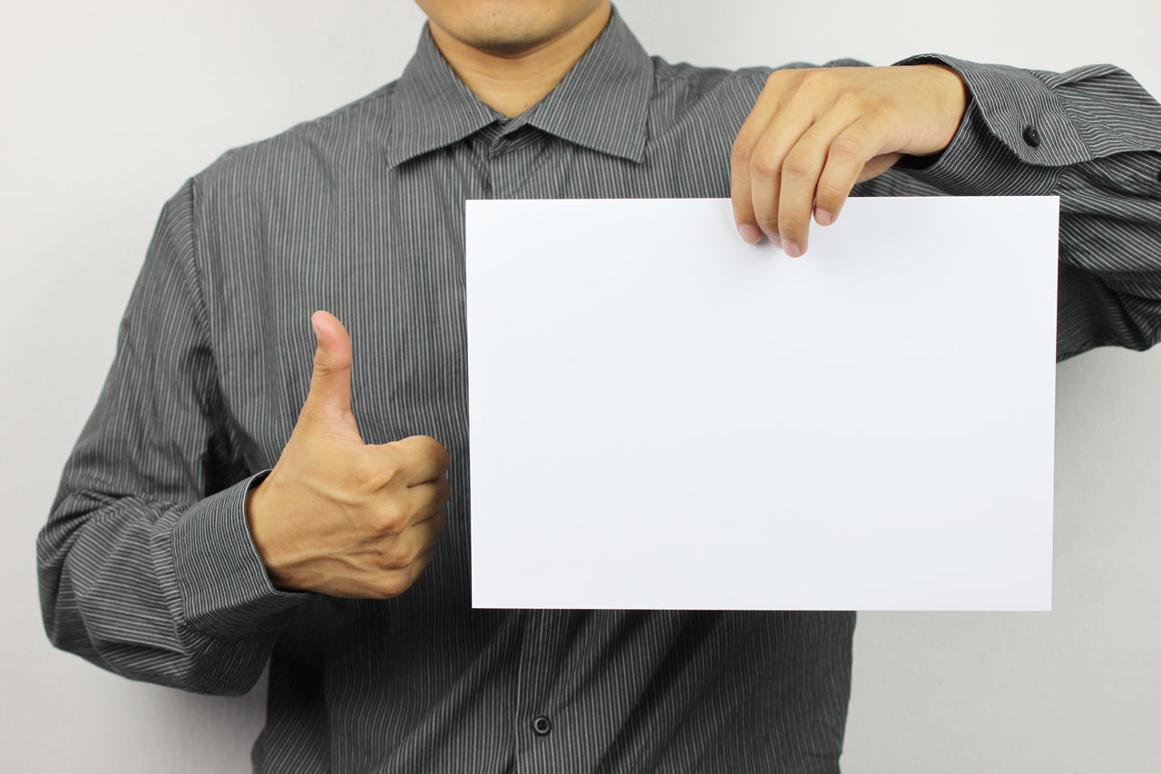 LOW SECTION OF MAN HOLDING PAPER