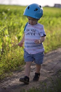 Rear view of boy walking on field