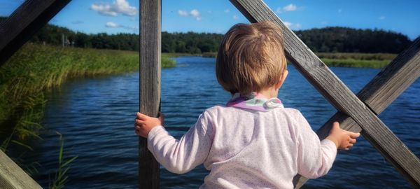 Rear view of a boy looking at lake