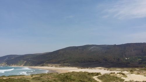 Scenic view of beach and mountains against sky