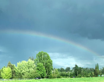 Scenic view of rainbow over landscape against sky