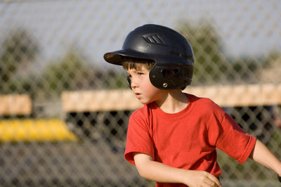 Young boy in baseball helmet concentrating on his hit