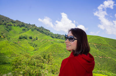 Portrait of young woman in sunglasses against sky