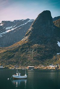 Scenic view of lake by mountains against sky