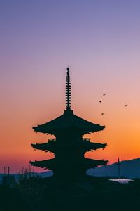 Silhouette of temple building against sky during sunset