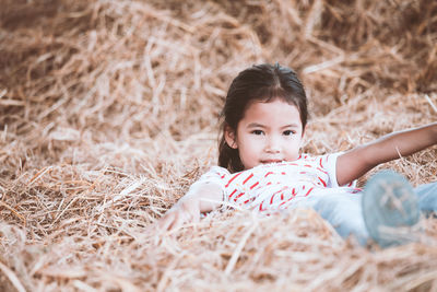 Portrait of girl playing on hay 