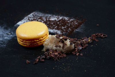 Close-up of macaroon with ground coffee on table
