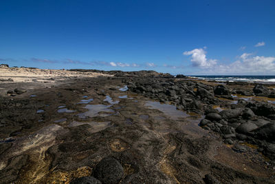 Rocks on beach against sky