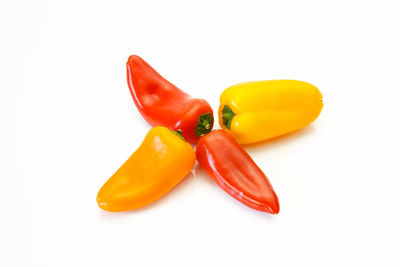 High angle view of yellow chili peppers on white background