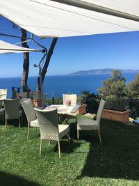 Empty chairs and table against sky