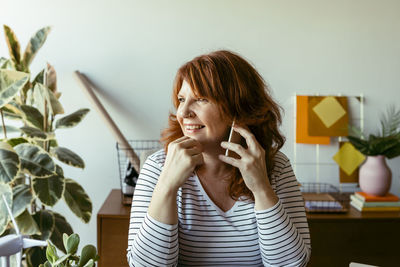 Portrait of a smiling young woman using mobile phone