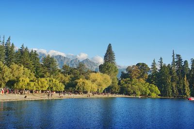 Panoramic view of people on lake against clear sky