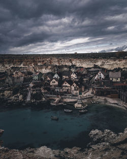 Aerial view of city against cloudy sky