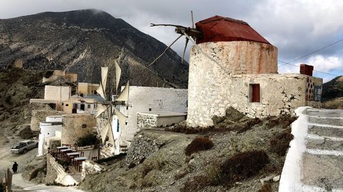 Old building by mountains against sky