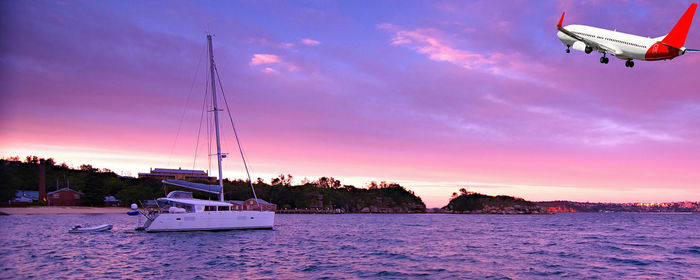 Sailboat sailing on sea against sky during sunset