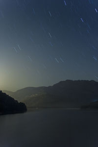 Scenic view of lake against sky at night