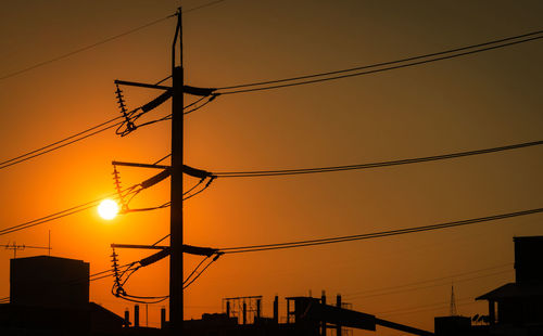 Low angle view of silhouette electricity pylon against romantic sky