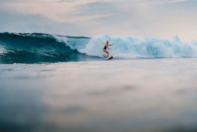 Man surfing on sea against sky