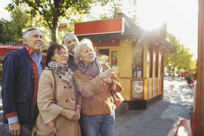 Male and female senior friends outside musical theater