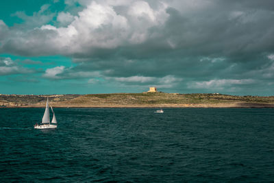 Sailboat sailing on sea against sky