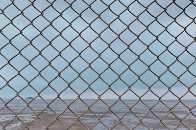 Full frame shot of chainlink fence against sky