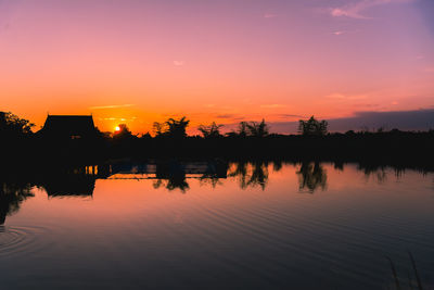 Scenic view of lake against orange sky