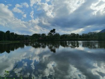 Scenic view of lake by trees against sky