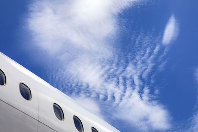 Fuselage of jet airplane against blue cloudy skies